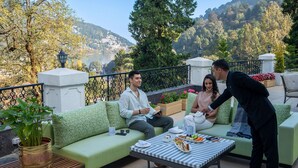 Una terraza con un sofá, una mesa y una planta en maceta.