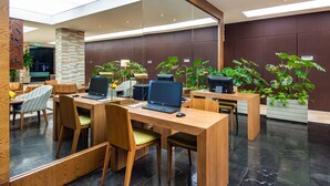 A modern office space with wooden desks, ergonomic chairs, and multiple laptops. - Holiday Inn Express Bogotá - Parque La 93 by IHG (Bogotá)