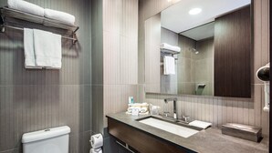 Une salle de bain moderne avec des toilettes, un lavabo et un miroir.