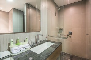 A modern bathroom with a large mirror, a sink with a towel rack, and a shower area. - Holiday Inn Express Bogotá - Parque La 93 by IHG (Bogotá)