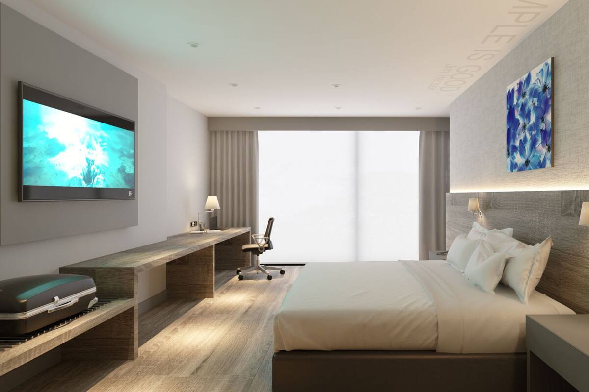 Una habitación de hotel moderna con una cama grande, un escritorio con televisor de pantalla plana, una maleta y un ventanal con cortinas.