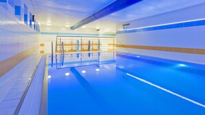A swimming pool with a blue tint, tiled walls, and a ventilation system. - Central Park Flora (Olomouc)
