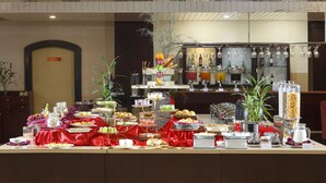 A buffet setup with various food items and beverages, a bar area with glassware, and a red carpeted floor. - Swiss-Belhotel Tarakan (Tarakan)
