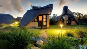A thatched-roof house with a small porch and a pathway leading to it. - Hawane Resort (Motshane)