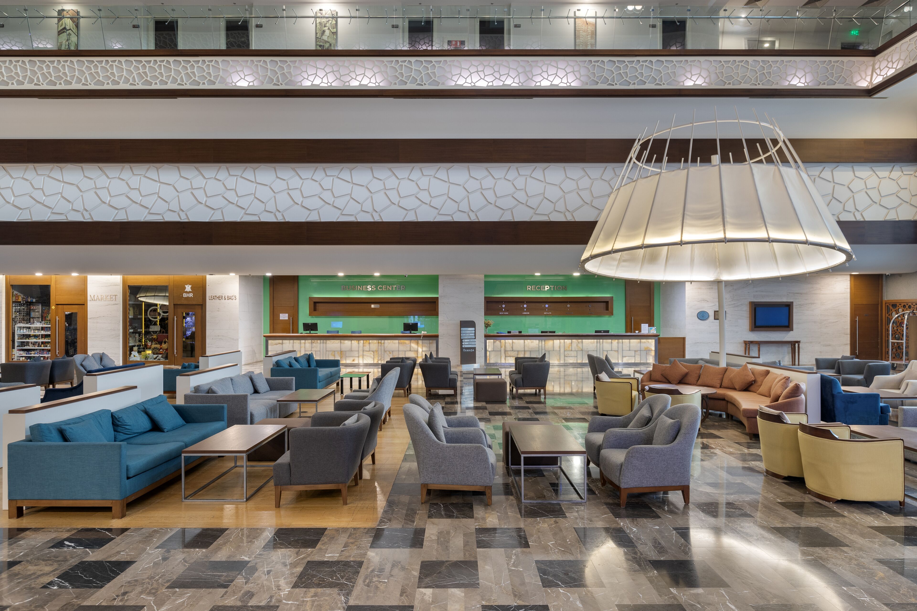 A spacious lobby with multiple seating areas, a reception desk, and a business center.