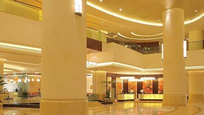 A spacious lobby with high ceilings, large columns, and a central reception area. - New Century Grand Hotel Changchun (Changchun)