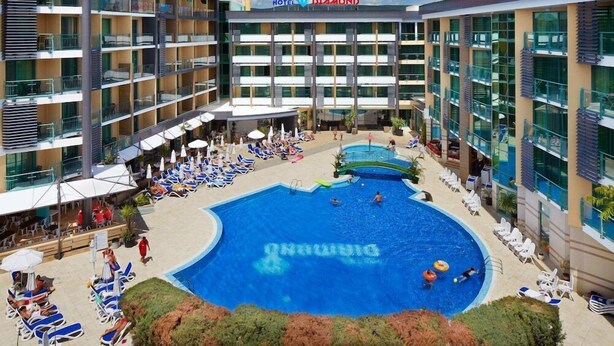 A hotel with a large pool area, multiple balconies, and outdoor seating. - Diamond Hotel (Sunny Beach)