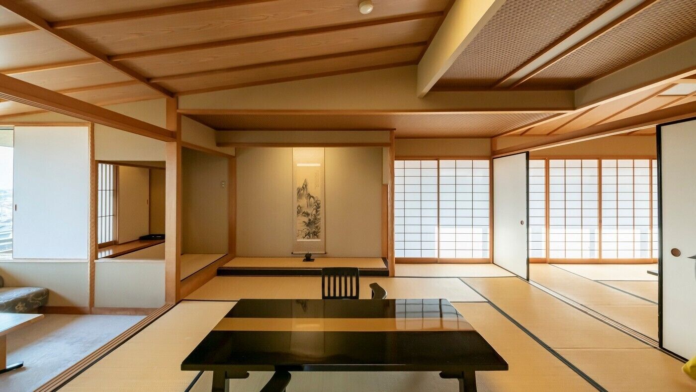 A tatami mat room with a tatami mat table, sliding doors, and a shoji screen.