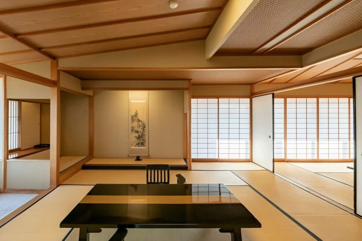A tatami mat room with a tatami mat table, sliding doors, and a shoji screen.