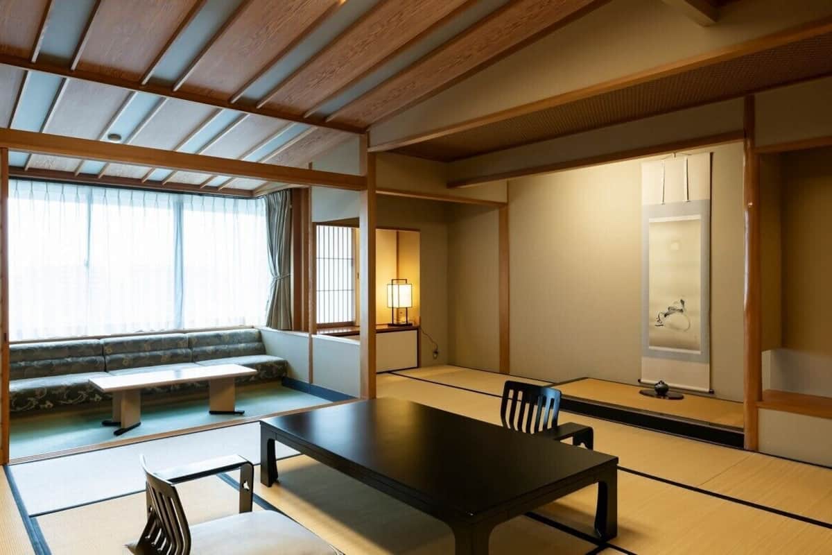 A traditional Japanese room with tatami flooring, a low table, a sofa, and sliding doors.