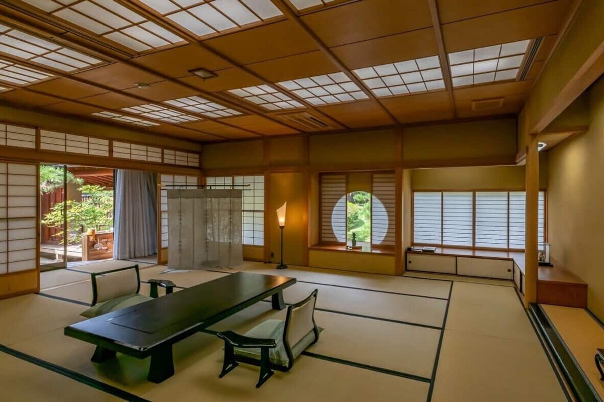 A traditional Japanese room with tatami flooring, a low table, and sliding doors.