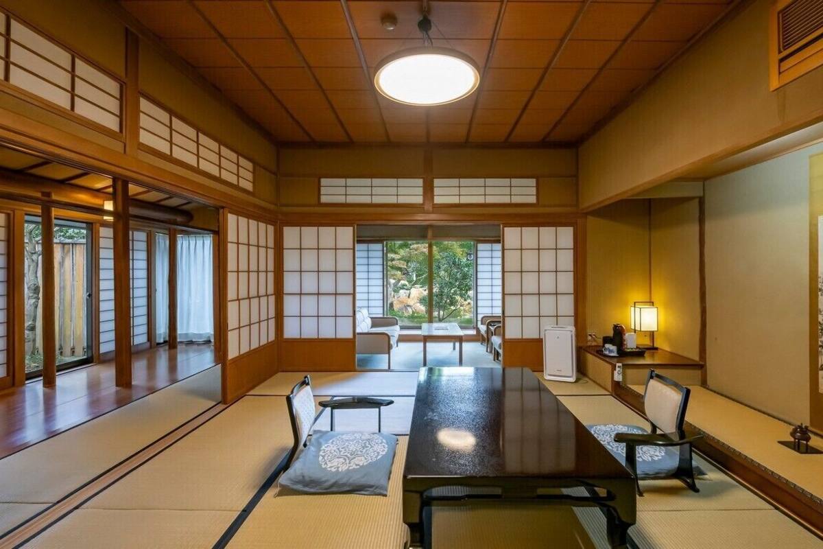 A traditional Japanese room with tatami flooring, a low table, and sliding doors.