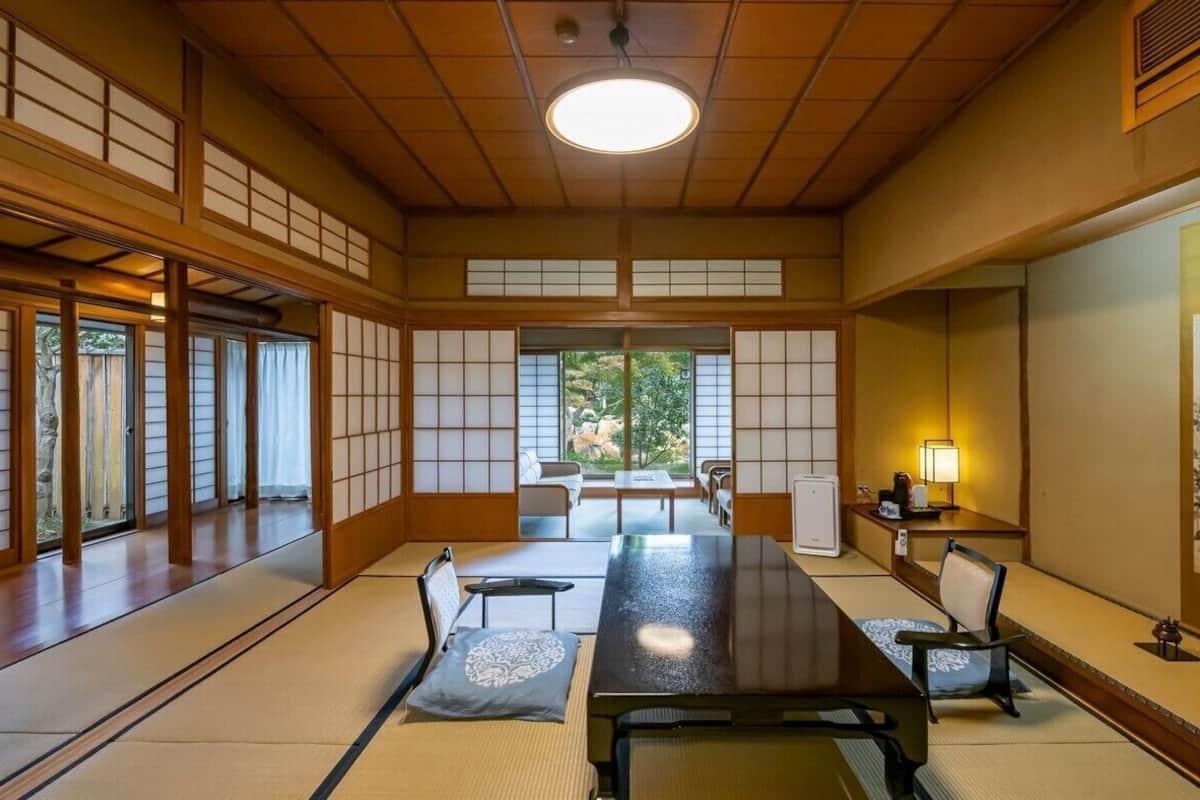 A traditional Japanese room with tatami flooring, a low table, and sliding doors.