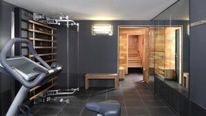 Une salle de sport moderne équipée d’un vélo d’appartement, d’un tapis de course et d’un banc en bois.
