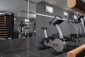 A modern gym with mirrored walls, exercise equipment, and a wooden bench. - Casa Camper Berlin (Berlin)