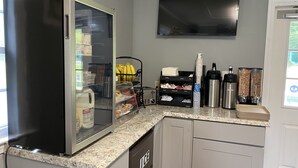 Eine Küche mit Kühlschrank, Kaffeemaschine und Mikrowelle.