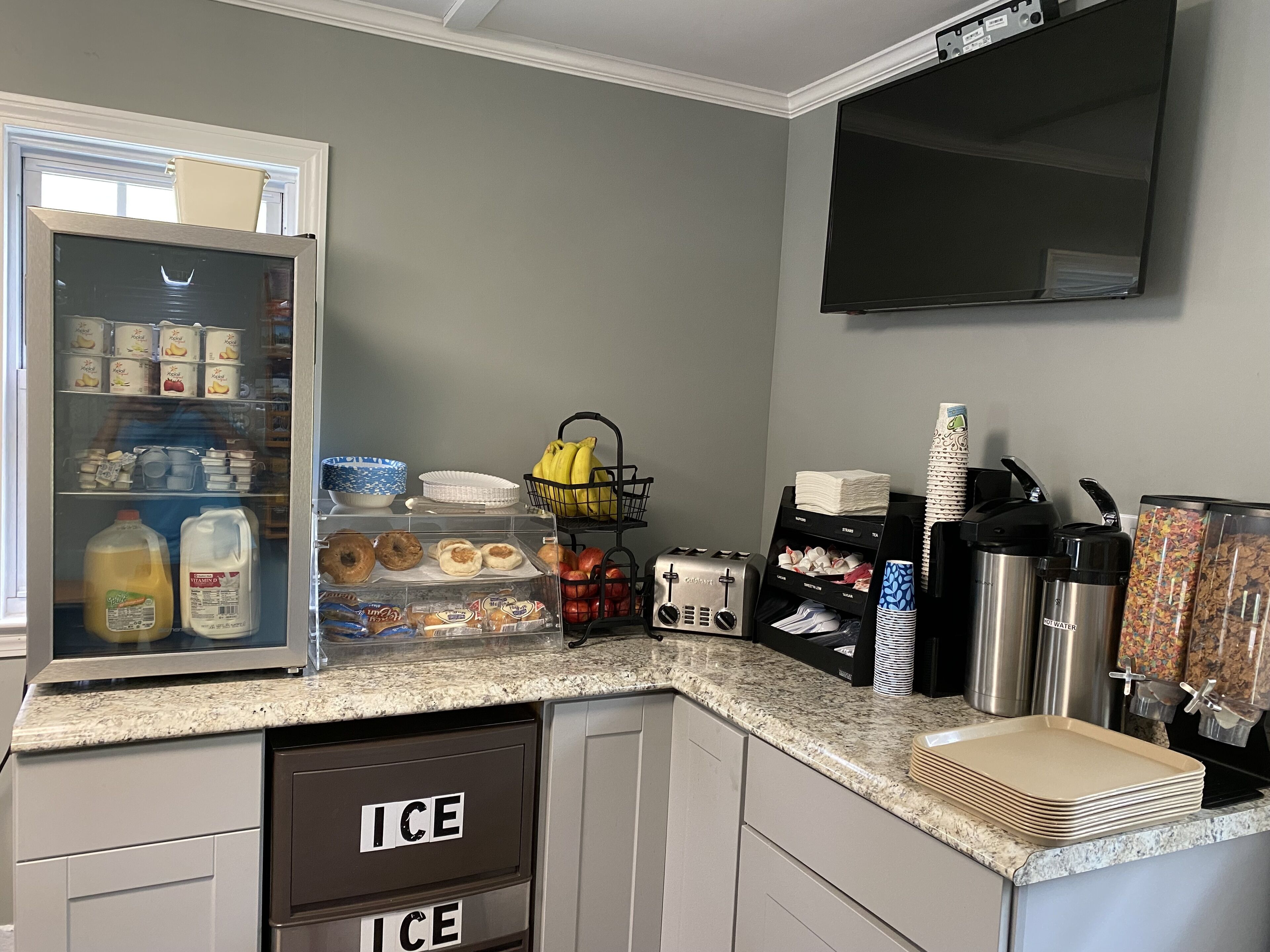 A kitchen with a refrigerator stocked with beverages, a toaster, and various kitchen utensils.