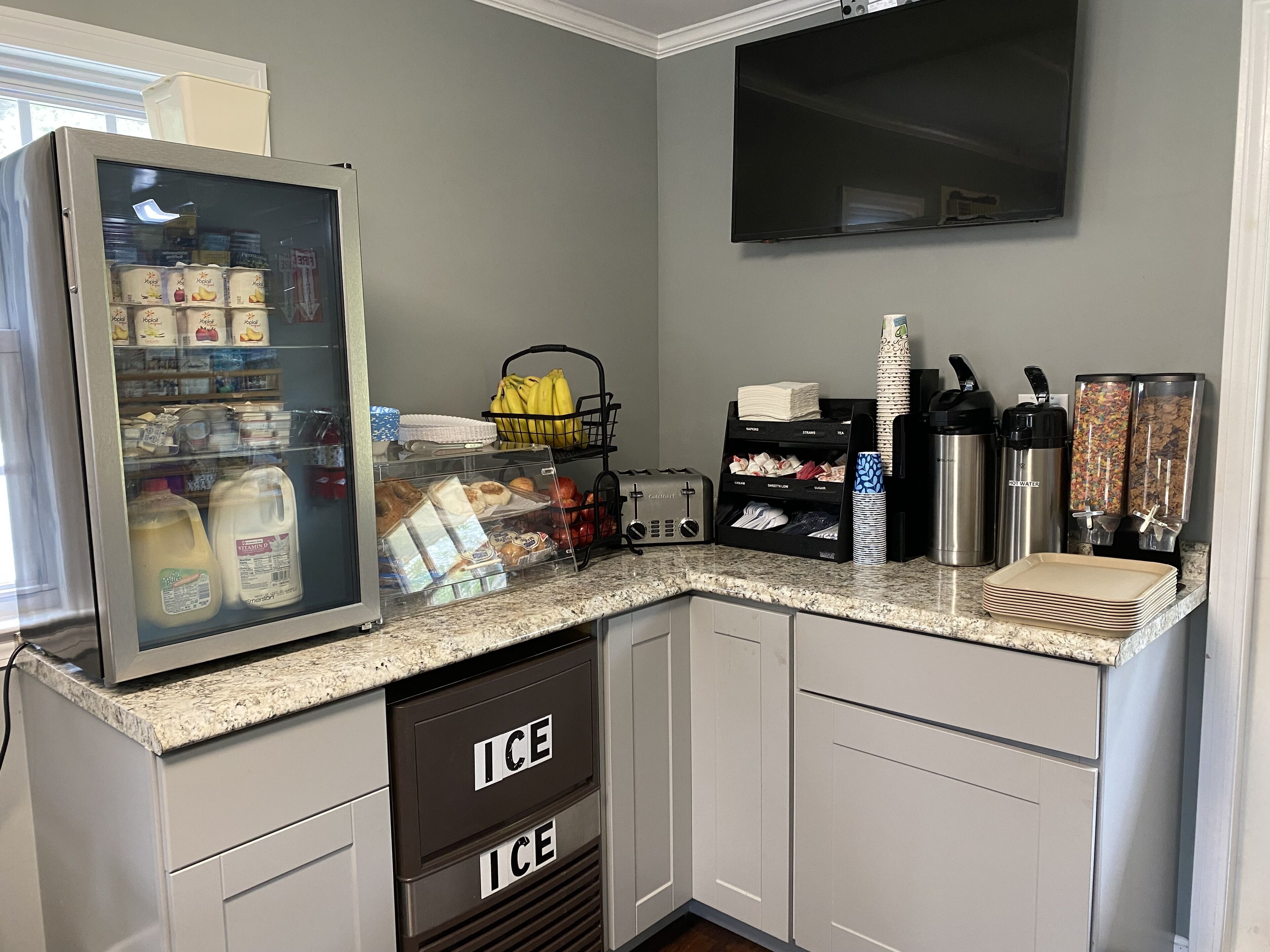 A kitchenette with a refrigerator stocked with beverages, a coffee maker, and a toaster.
