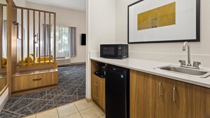 Una cocina moderna con microondas, pileta y muebles de madera.
