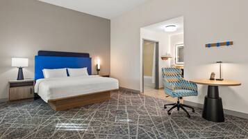 Ein Hotelzimmer mit Bett, Schreibtisch, Stuhl und einem kleinen Tisch.