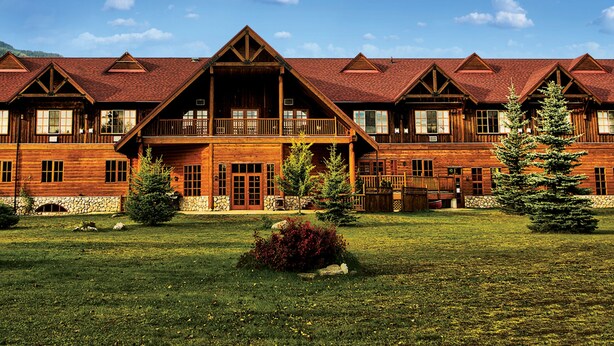 Un gran albergue de madera con varios balcones y cimientos de piedra.