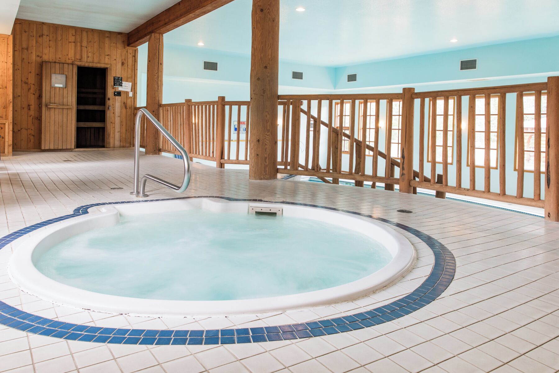 Ein Whirlpool mit einer Holzterrasse und einem Metallgeländer.
