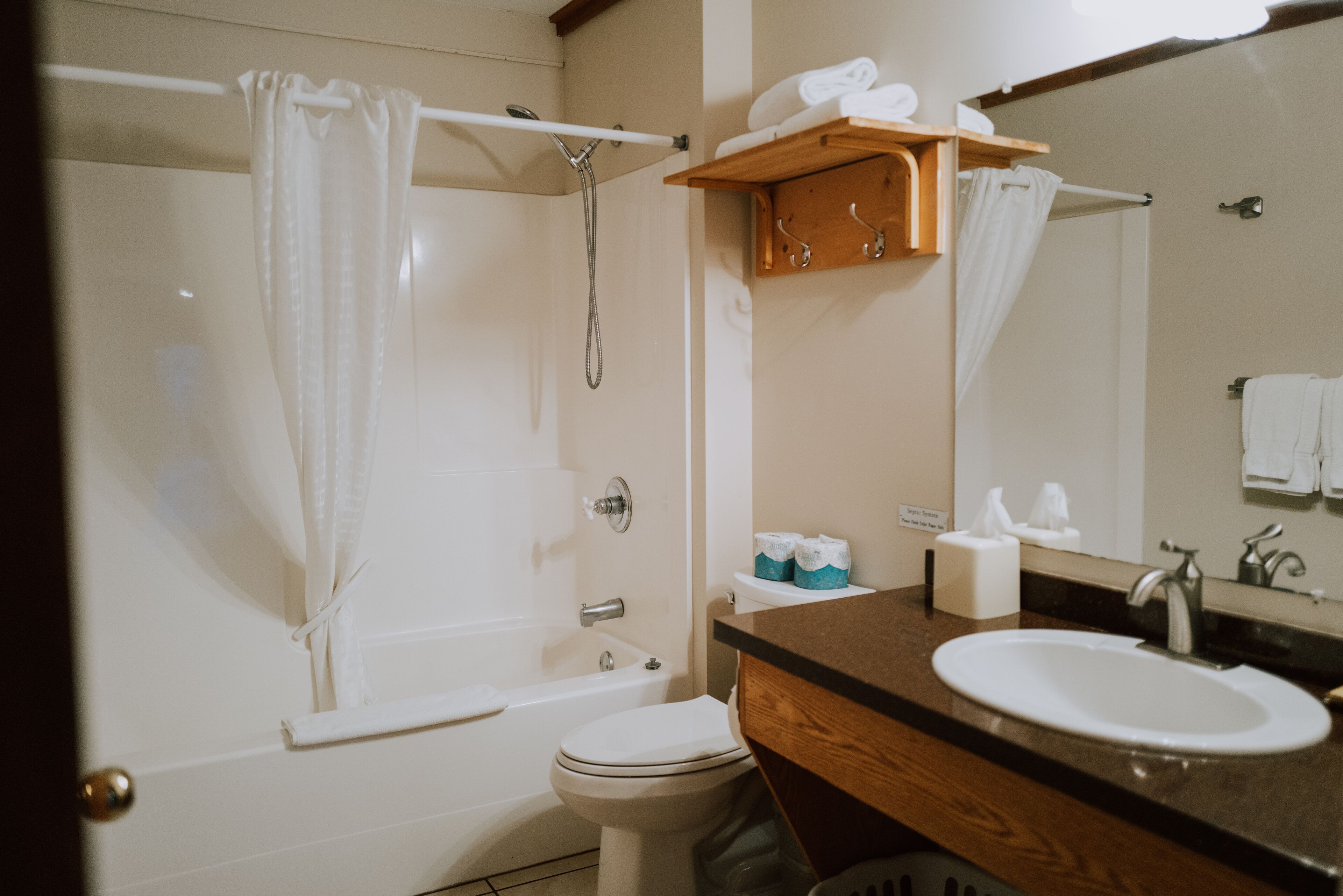 Un baño con bañera, inodoro, lavamanos y espejo.