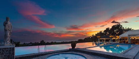 Una piscina al aire libre, sombrillas, sillones reclinables de piscina