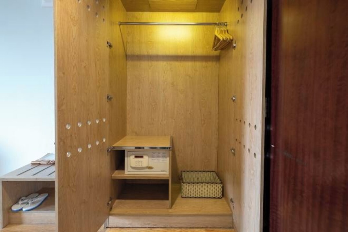 Una habitación pequeña de madera con radio integrada, un estante y una cesta.