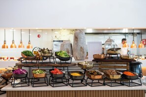 A buffet setup with various food items arranged on stands. - King Jason Paphos - Designed for Adults By Louis Hotels (Paphos)