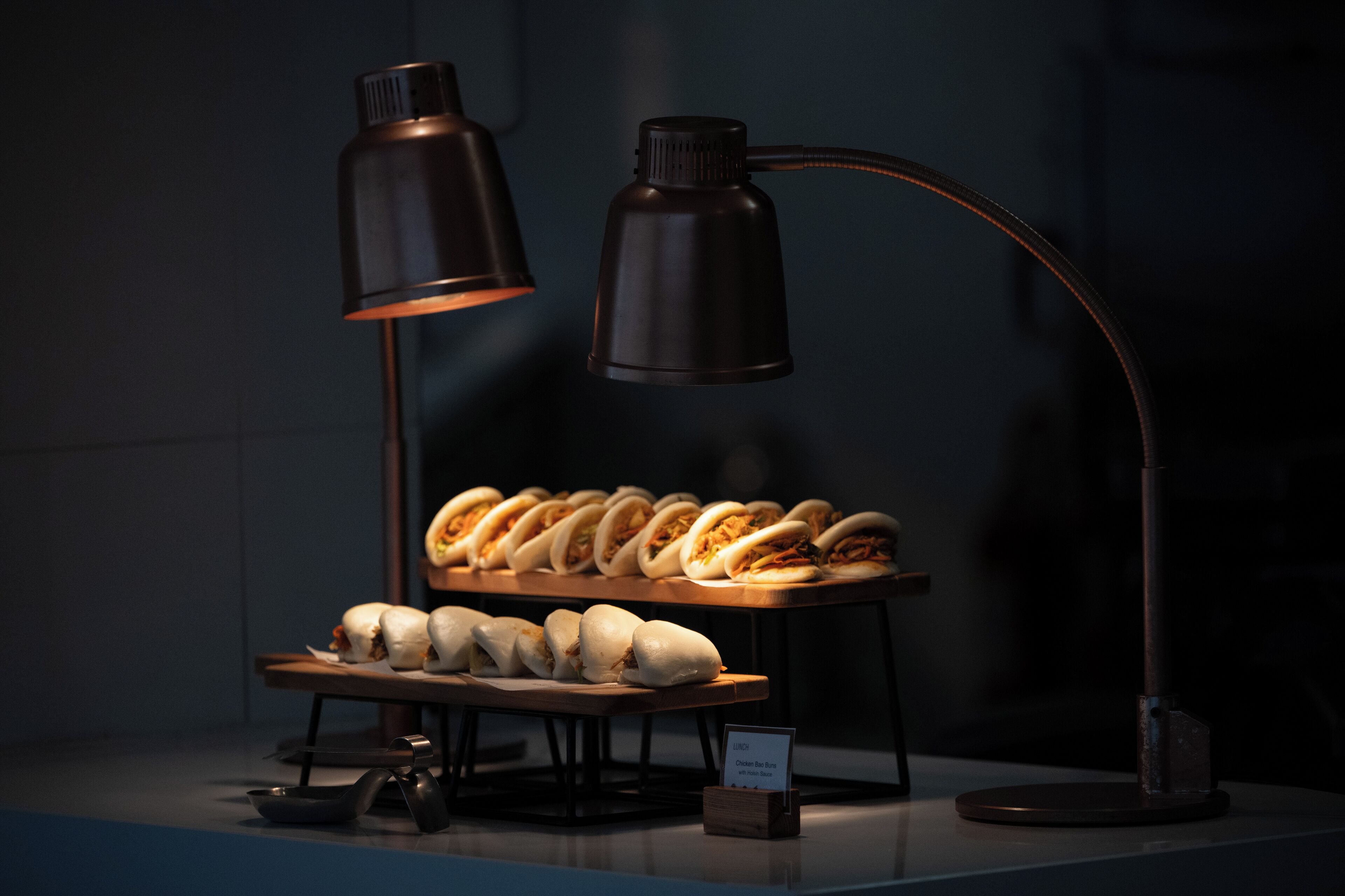 A display of food items under a desk lamp in a dimly lit room.