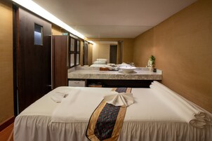 Una habitación de hotel con cama, baño con lavamanos y espejo, y una puerta.