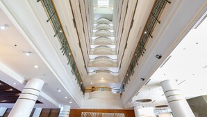 Un atrium à plusieurs niveaux, doté d’un espace central ouvert, de colonnes et de rampes.