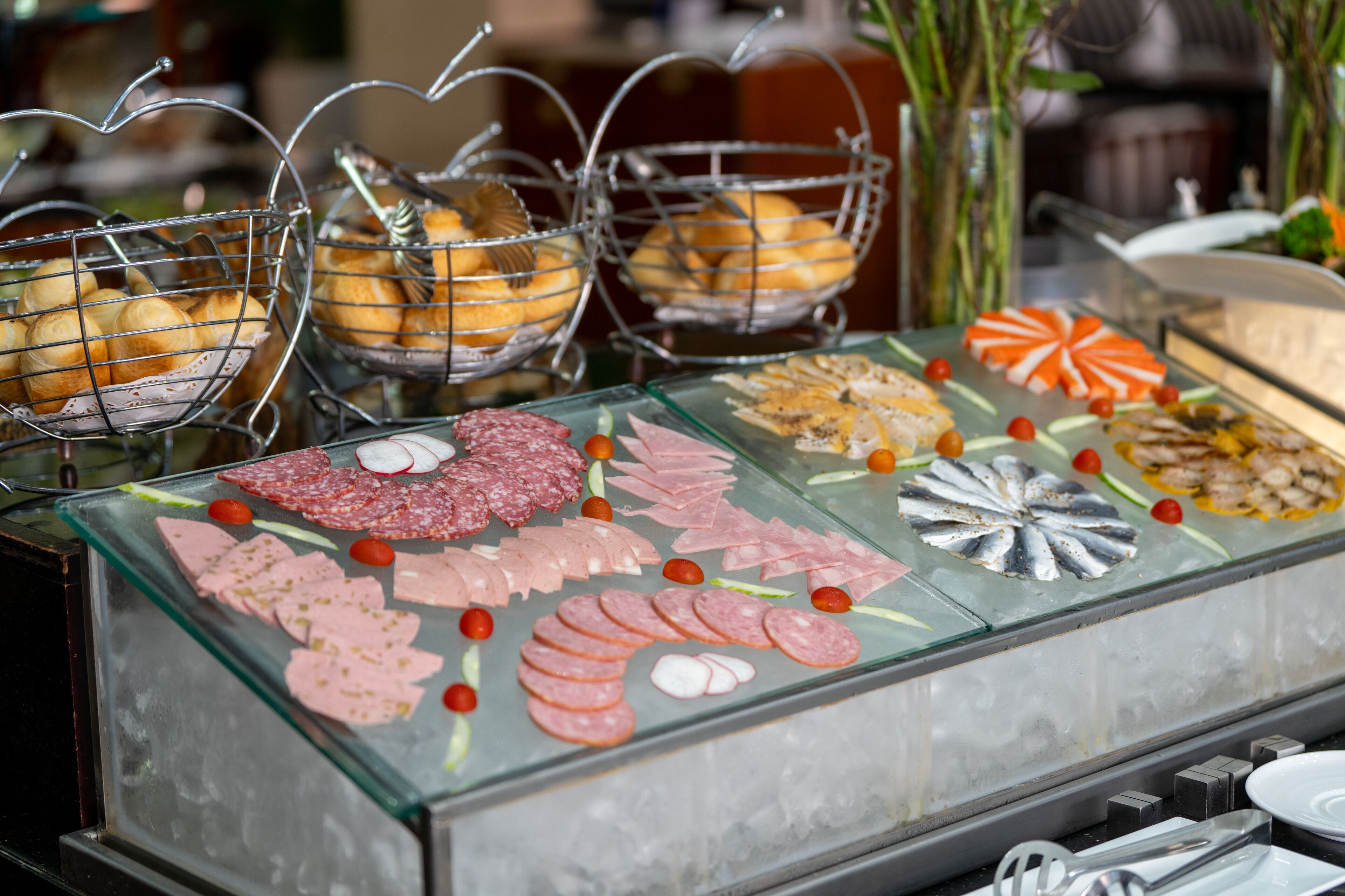 A buffet with various food items including meats, cheeses, and pastries.
