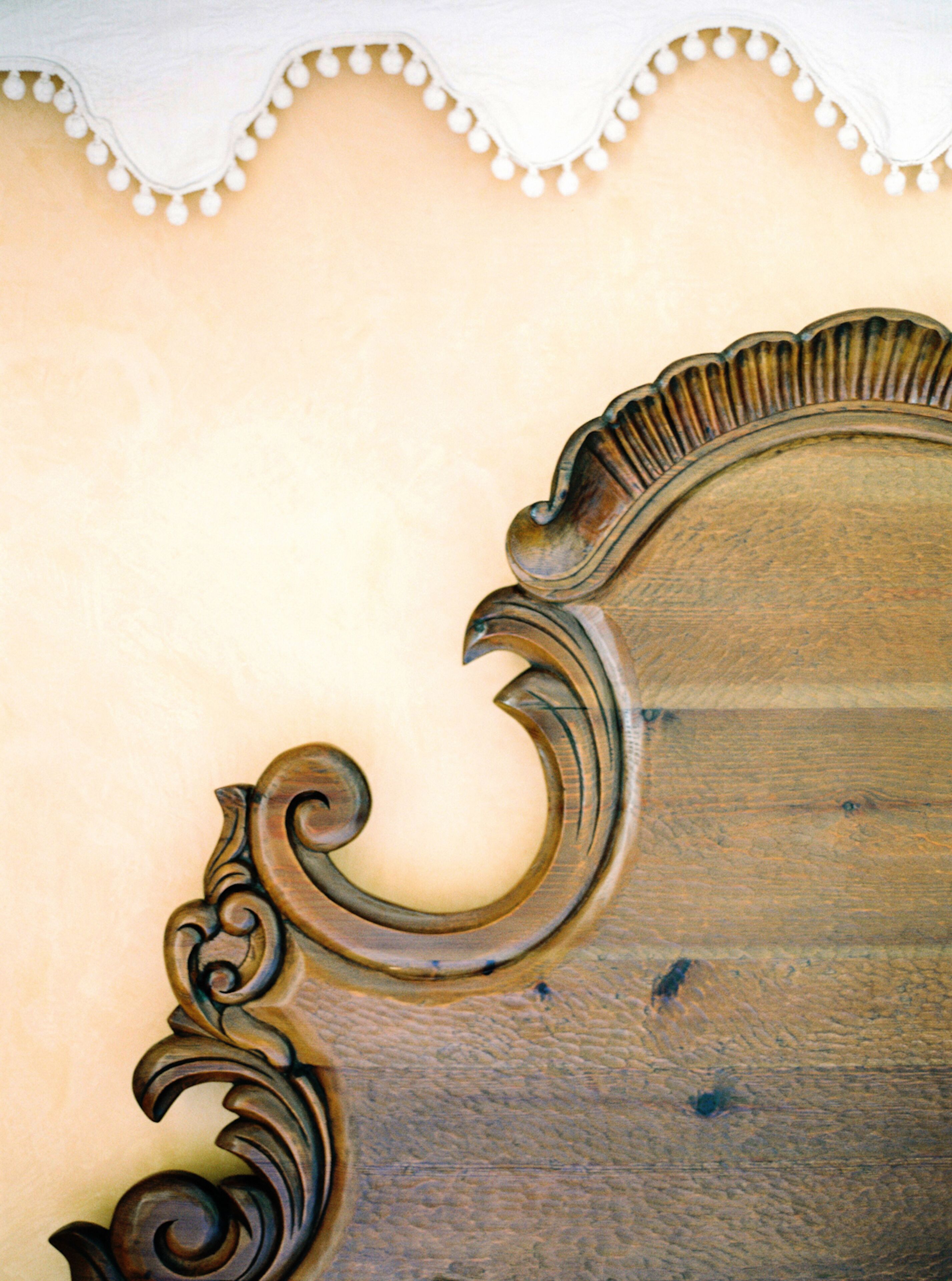 Primer plano de un mueble de madera con intrincados adornos y un borde ondulado.