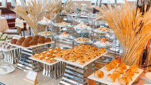 A buffet with various pastries and desserts displayed on trays and in glass containers. - Muong Thanh Luxury Song Han Hotel (Da Nang)
