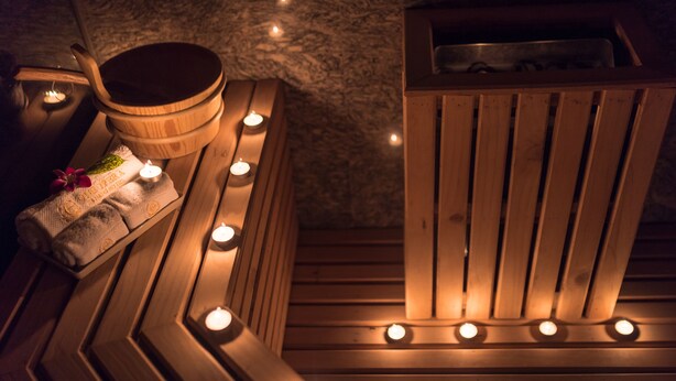 A wooden sauna with multiple benches and candles. - Muong Thanh Luxury Song Han Hotel (Da Nang)