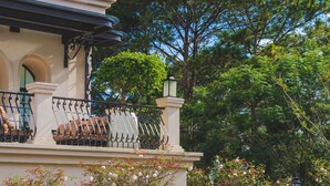 A building with a balcony, a lamp post, and a tree in the background. - Grand Mercure Dalat (Lam Vien - Da Lat)