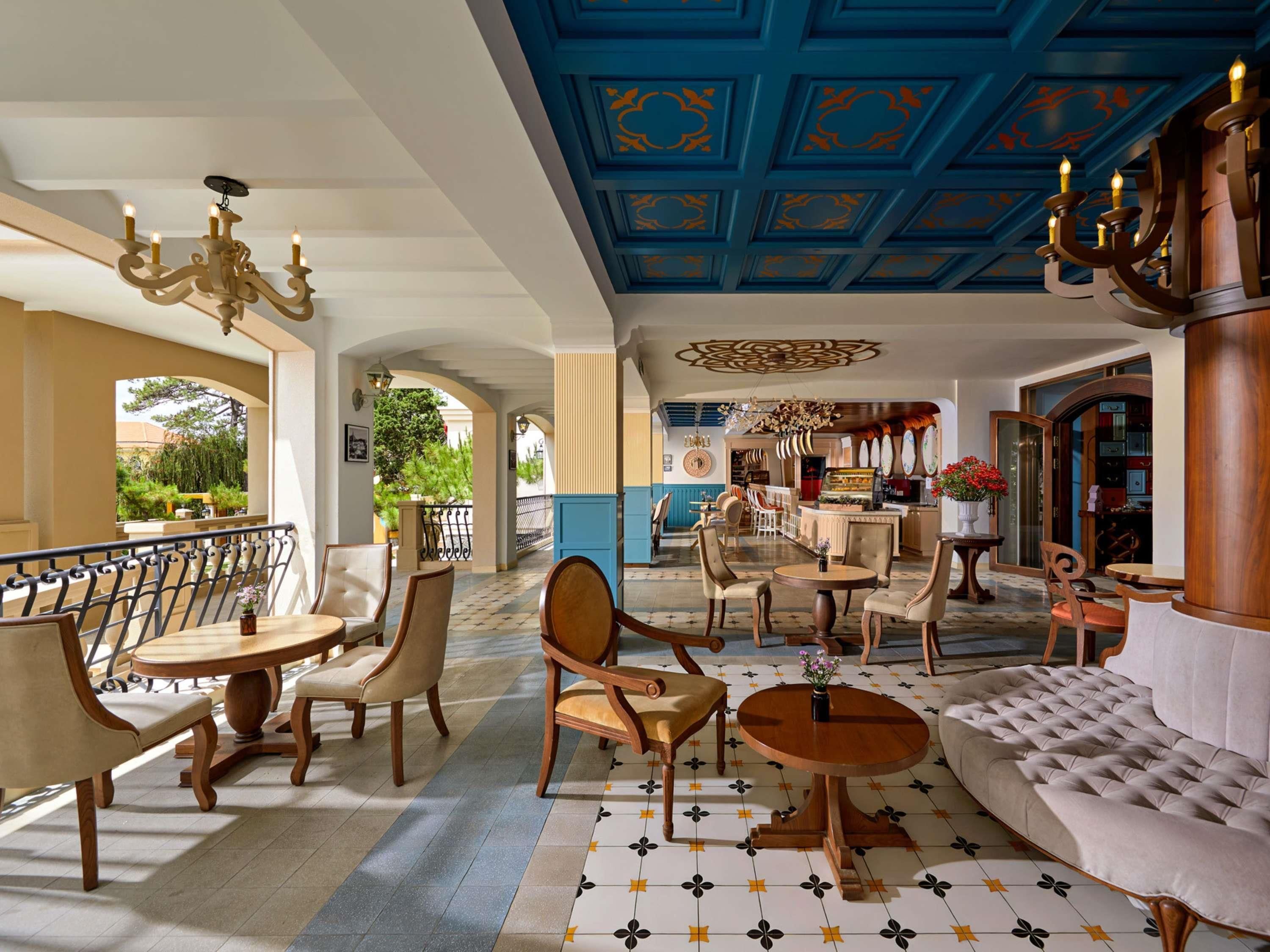 A hotel lobby with a bar area, seating arrangements, and a decorative ceiling.