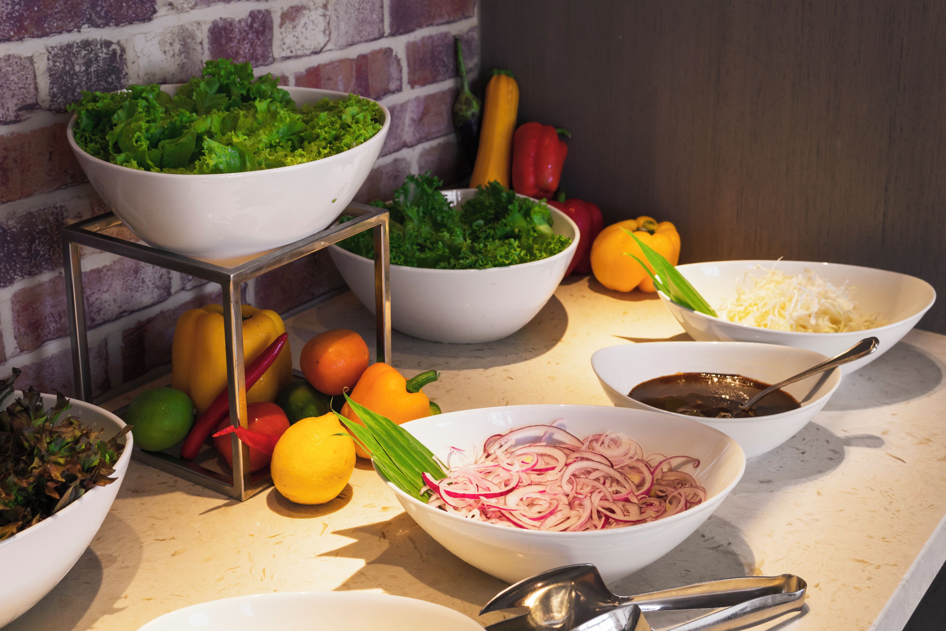A kitchen counter with various bowls containing food items and vegetables.