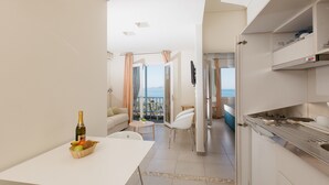 A modern kitchen with a dining area, a view of the sea, and a balcony. - Ikion Eco Boutique Hotel (Alonissos)