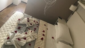 Ein Bett mit gesteppter Bettdecke, weißen Kissen und einer Wand mit floralem Dekor.