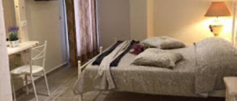 A bedroom with a bed, a desk, and a chair.