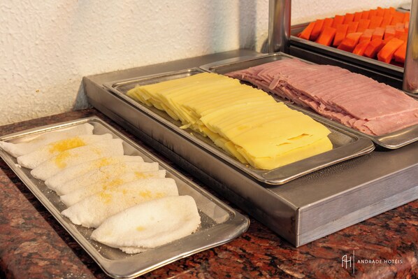 A buffet with various food items including bread, cheese, and ham.
