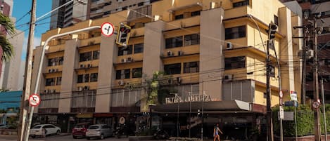 A hotel with multiple floors, balconies, and a sign indicating it is a hotel.