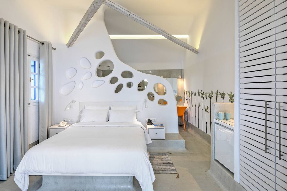 Un dormitorio moderno con una cama grande, una mesita de noche y un armario empotrado.