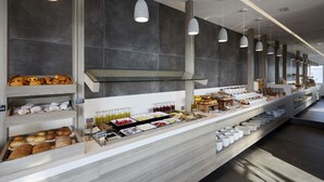 A buffet setup with various food items and beverages. - Kouros Village Hotel - Adults Only (Santorini)