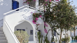 A white building with a staircase, blue doors, and cacti. - Kouros Village Hotel - Adults Only (Santorini)