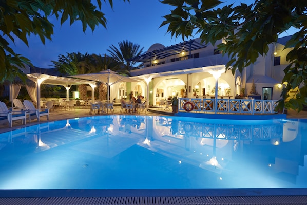 Una piscina al aire libre, sombrillas