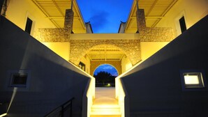 Una escalera conduce a un arco de piedra con vista al cielo al anochecer.